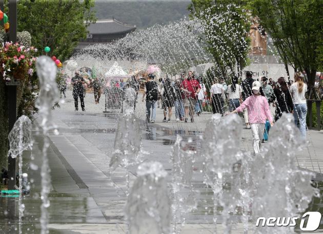 서울 세종대로 광화문광장 분수대를 찾은 시민들이 물줄기를 지나고 있다. 2023.5.21/뉴스1 ⓒ News1 이동해 기자