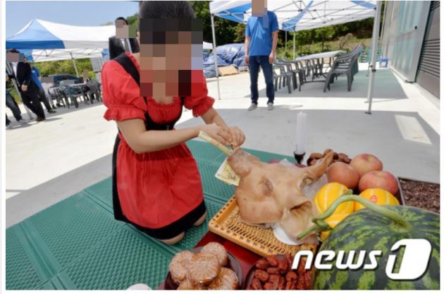 고사상 돼지머리에 돈을 꽂고 있는 모습. (사진은 기사 내용과 무관함) / 뉴스1 ⓒ News1 DB